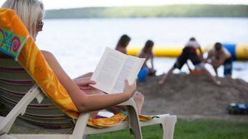A person reading a book on a beach chair.
