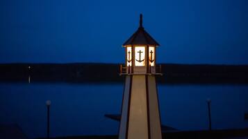 A lighthouse with a light at the top, situated near a body of water.