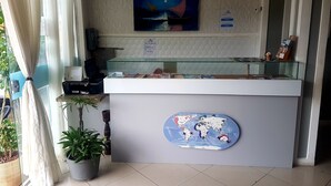 Una recepción con un mapa mundial, un reloj y un cuadro de un velero.