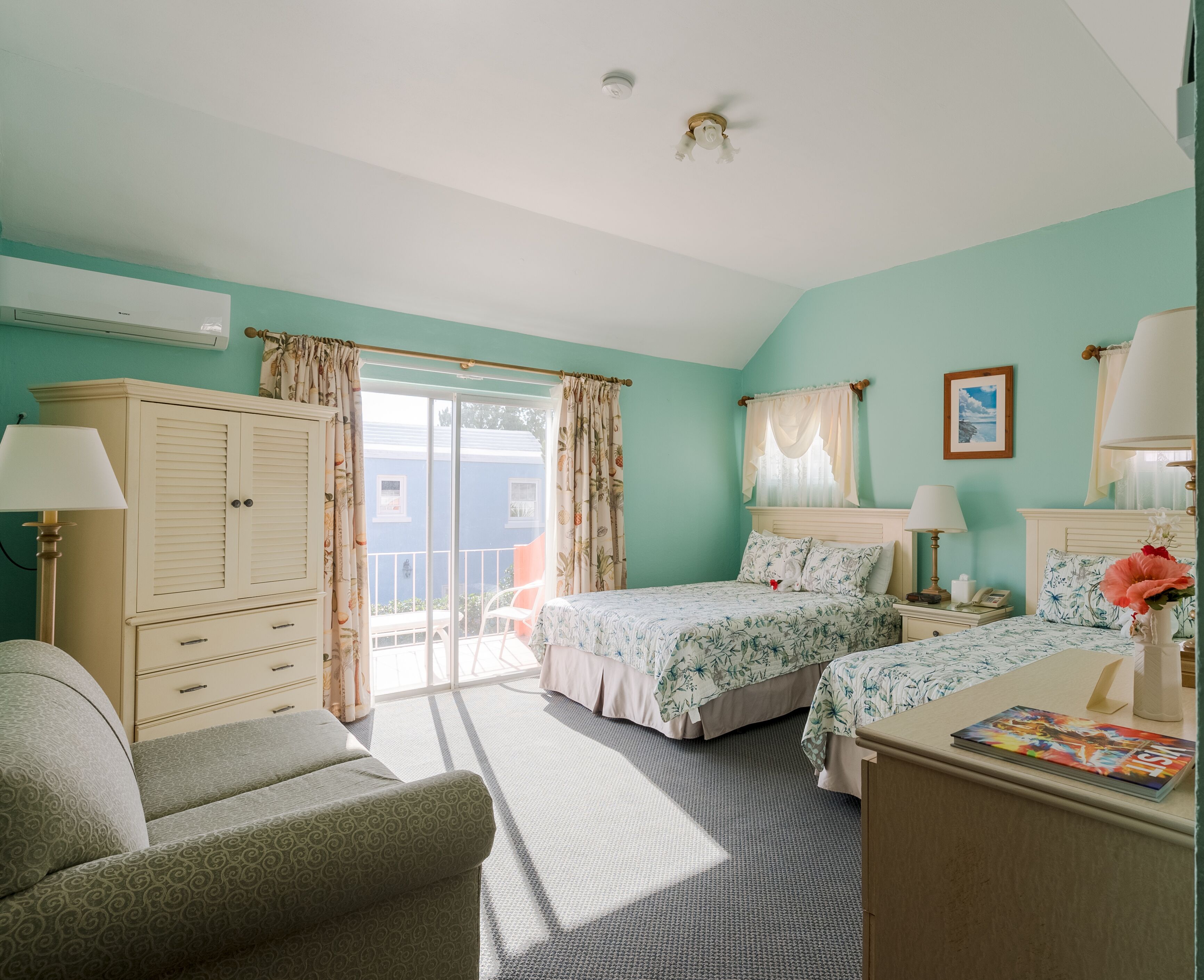 A bedroom with two beds, a wardrobe, a chair, a desk, and a window with curtains.