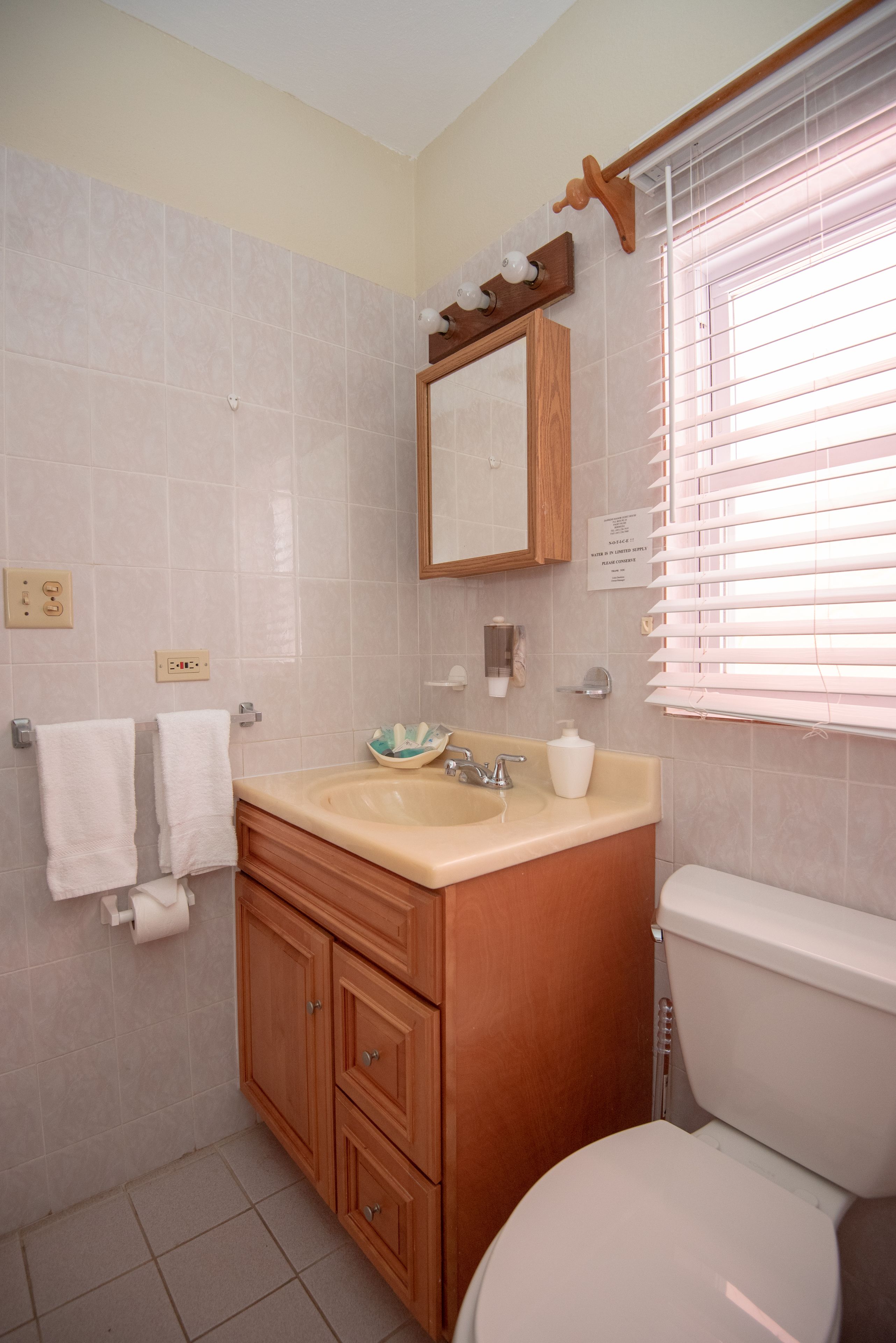 Een badkamer met toilet, wastafel en badkamermeubel.