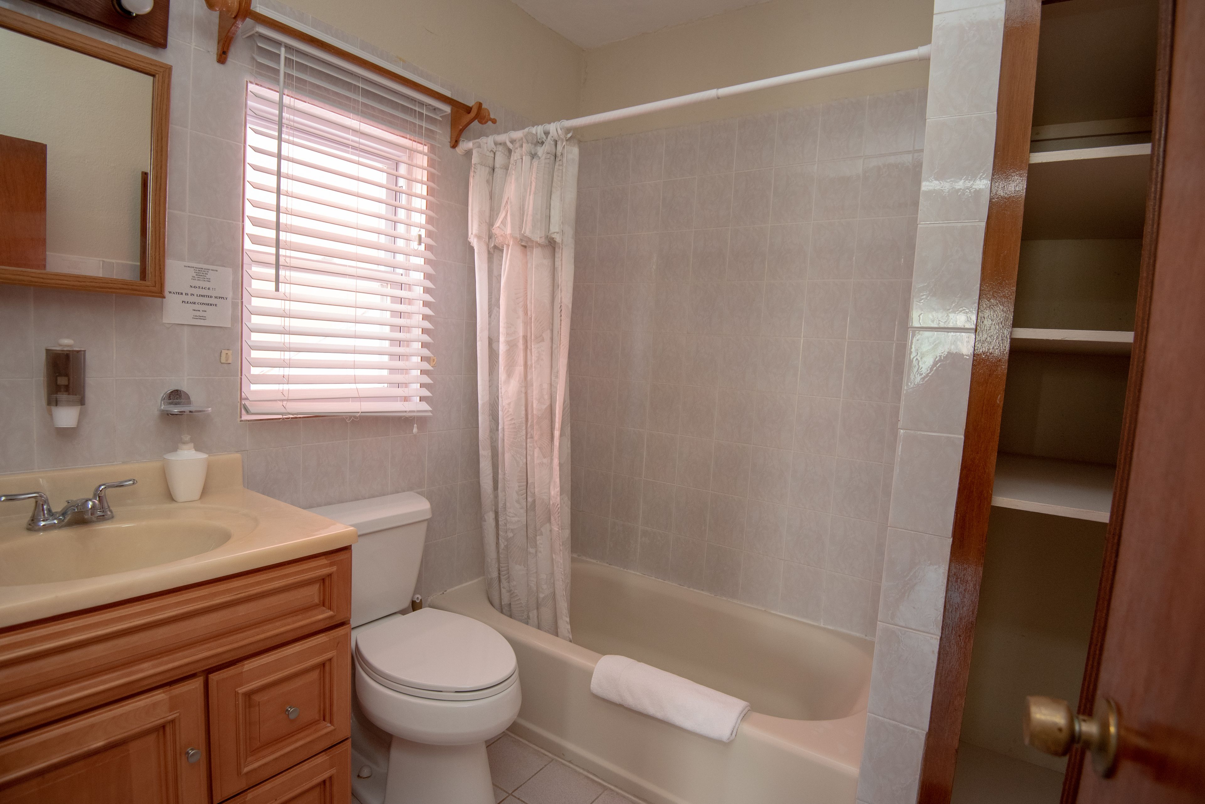A bathroom with a toilet, sink, vanity, and bathtub.