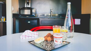 A breakfast table with scrambled eggs, croquettes, and a bottle of Chobani yogurt. - LiA Hotel (San Carlos)