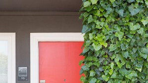 A red door with a keypad lock, surrounded by lush green ivy. - LiA Hotel (San Carlos)