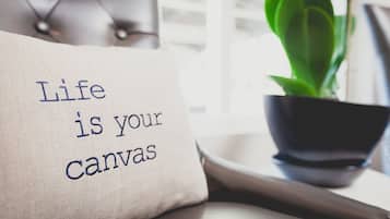 A pillow with the text "Life is your canvas" and a potted plant.