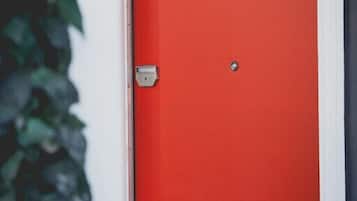 Una puerta roja con picaporte plateado y cerradura.