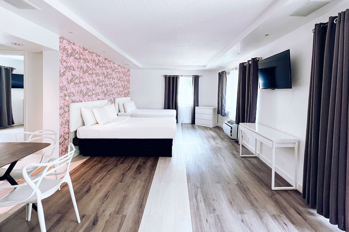 Moderni hotellihuone, jossa on suuri sänky, työpöytä ja televisio.