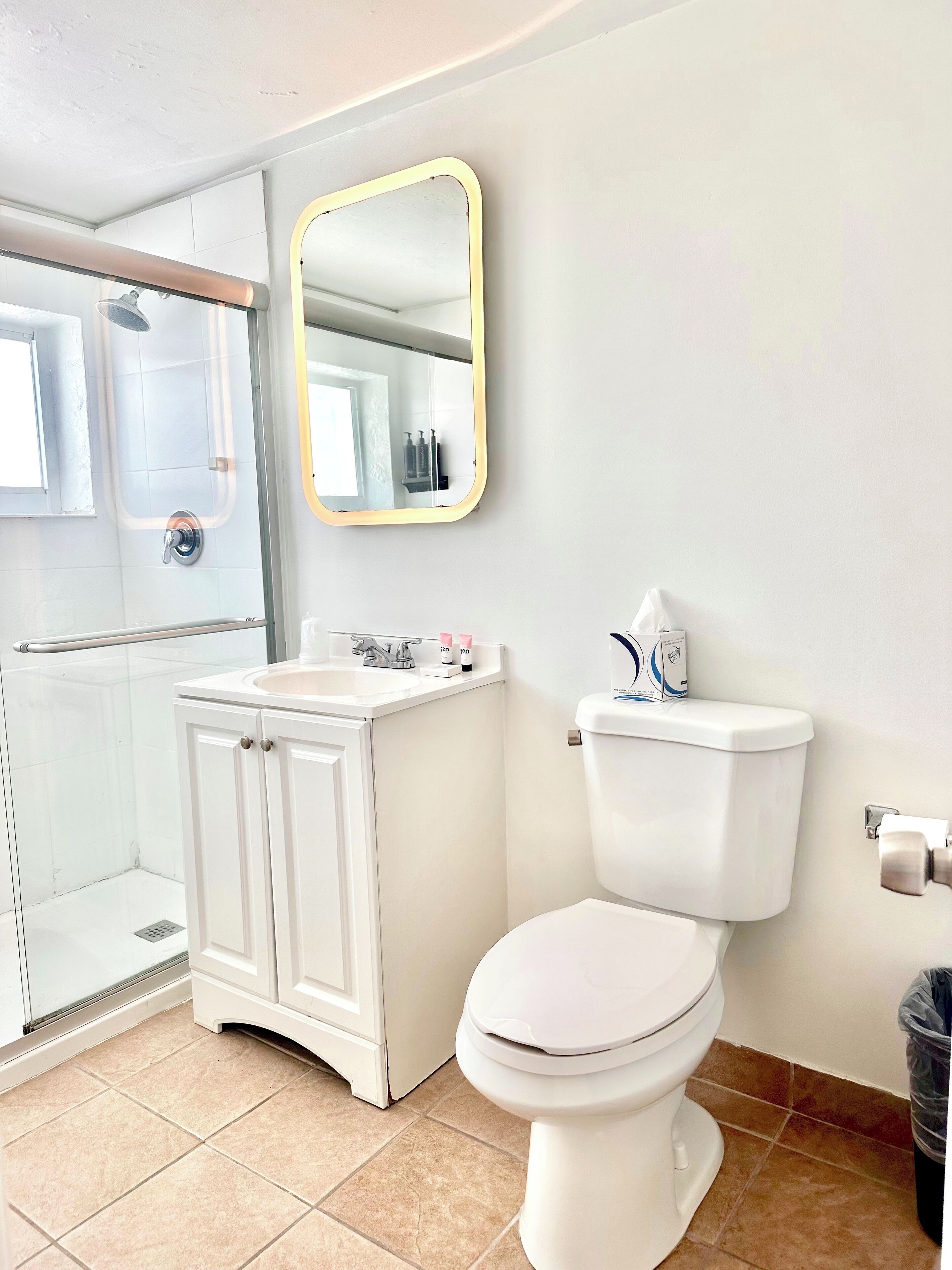 Un baño con inodoro, lavamanos y ducha.