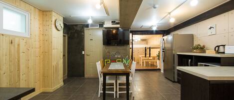 A modern kitchen with a wooden dining area, a large island, and a built-in oven.