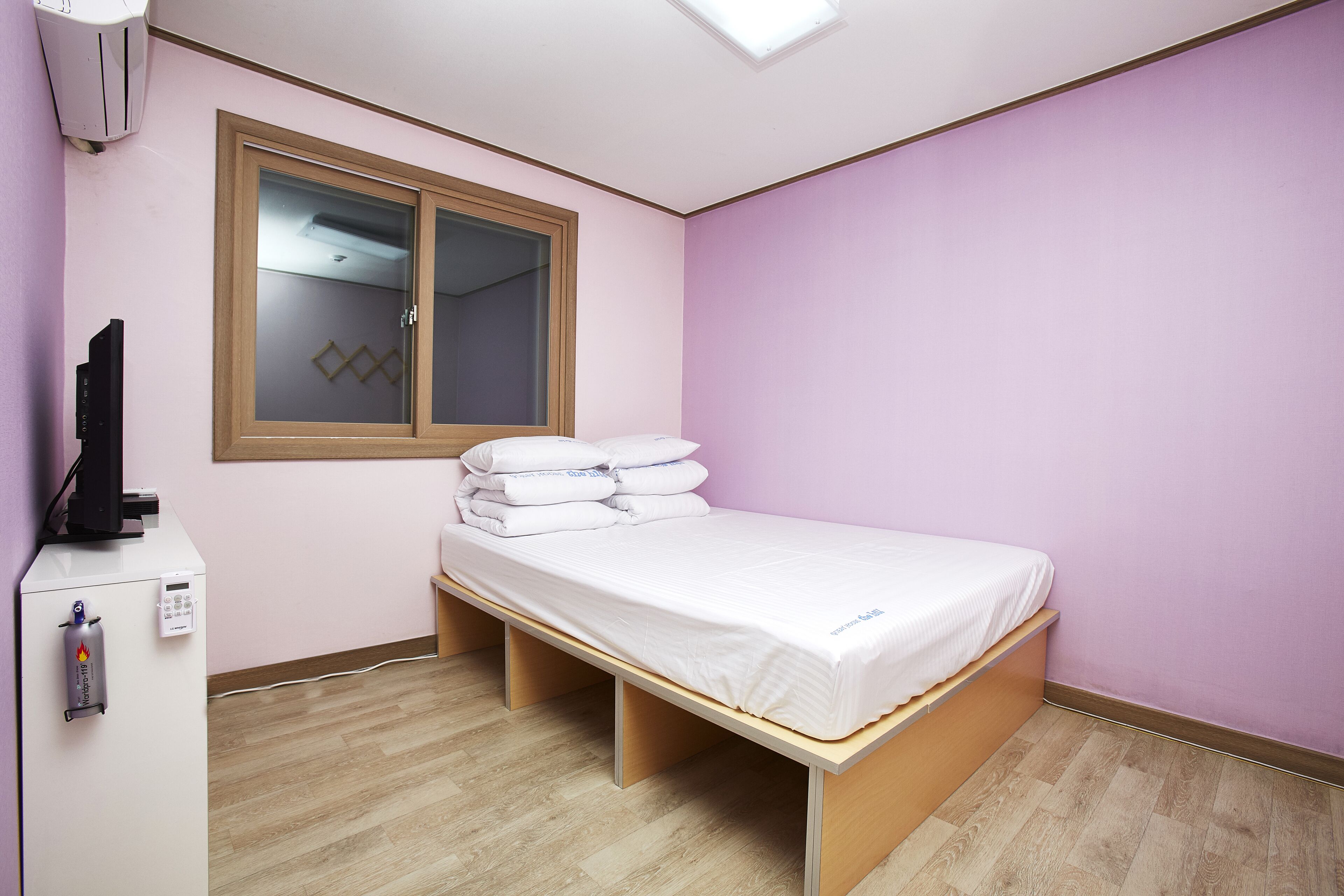 Una habitación con una cama, un escritorio y una ventana.