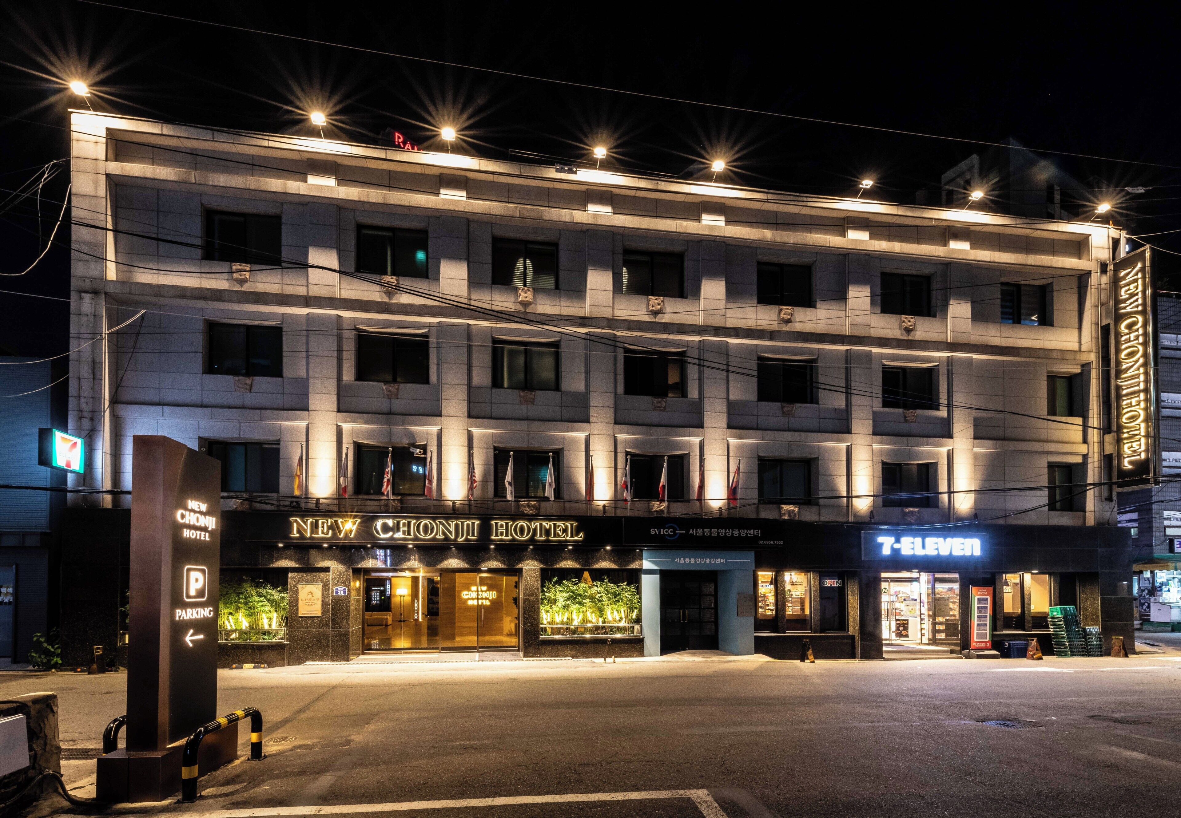 A multi-story hotel with a modern facade, illuminated signage, and a prominent entrance.