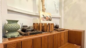 A wooden bench with a display of traditional pottery and a painting of vases. - Cocoa Guesthouse (Seoul)