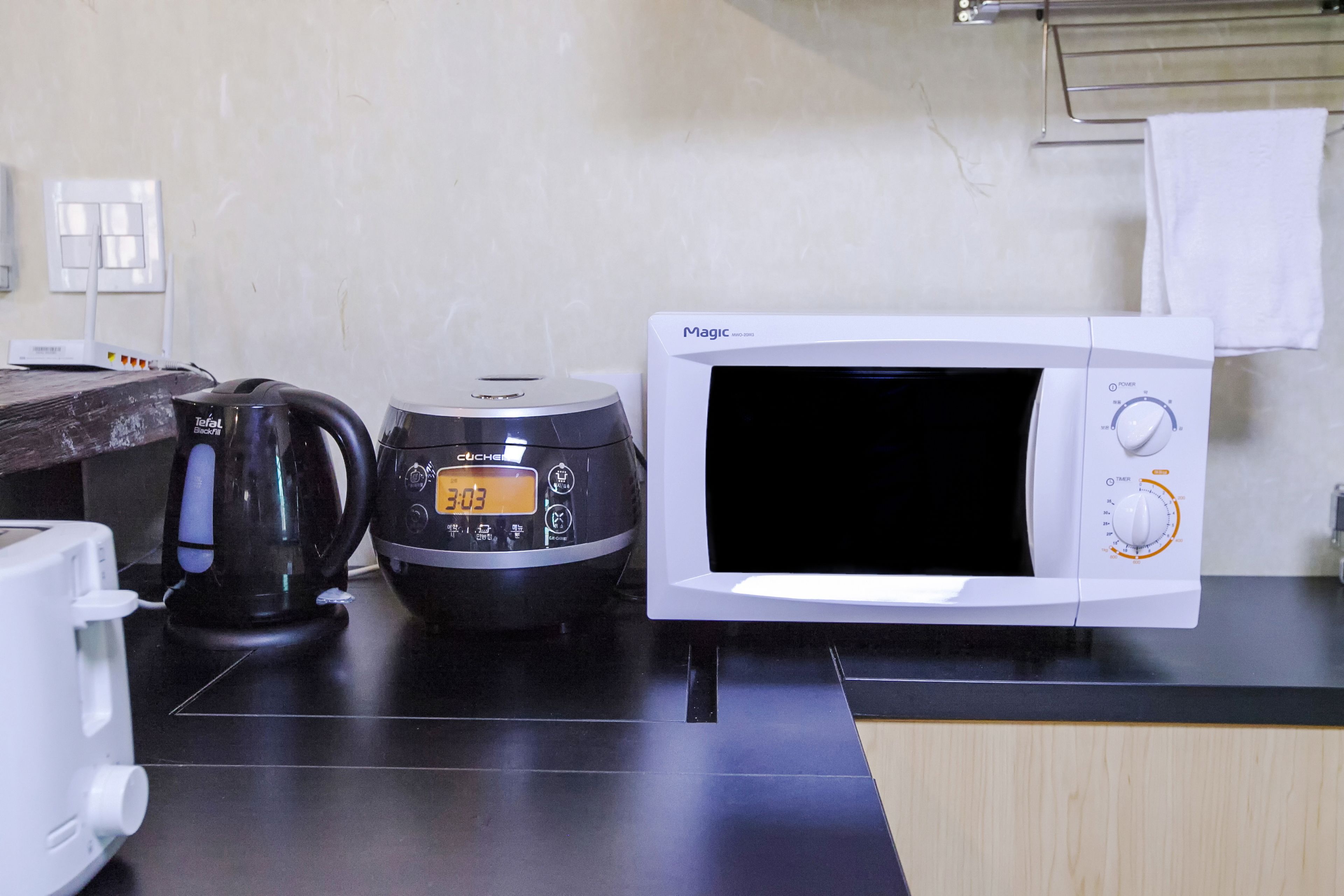 A kitchen with a microwave, a coffee maker, and a toaster on the counter.