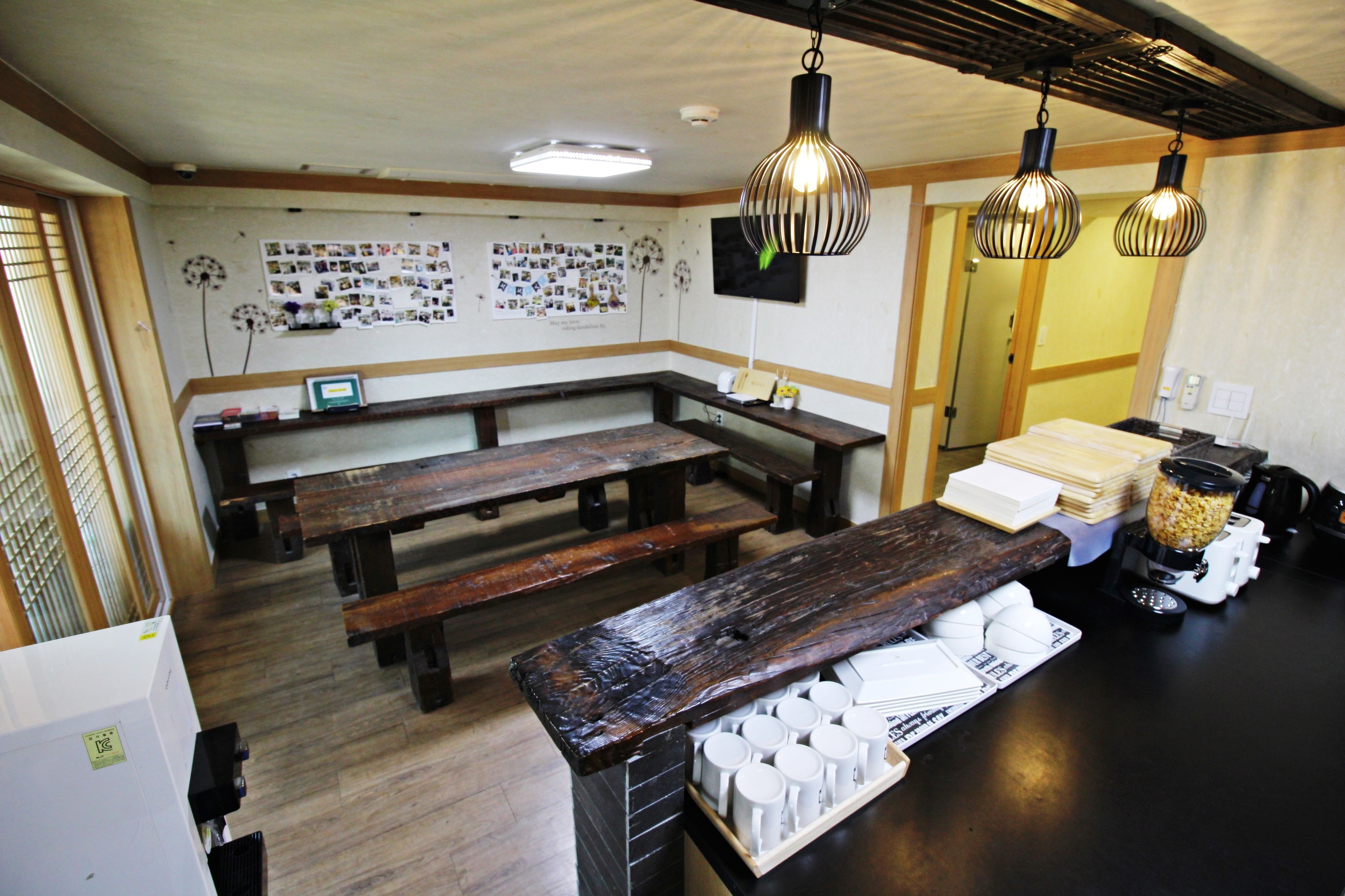 Un restaurant avec des bancs en bois, un appareil à café et un mur décoré de photos.