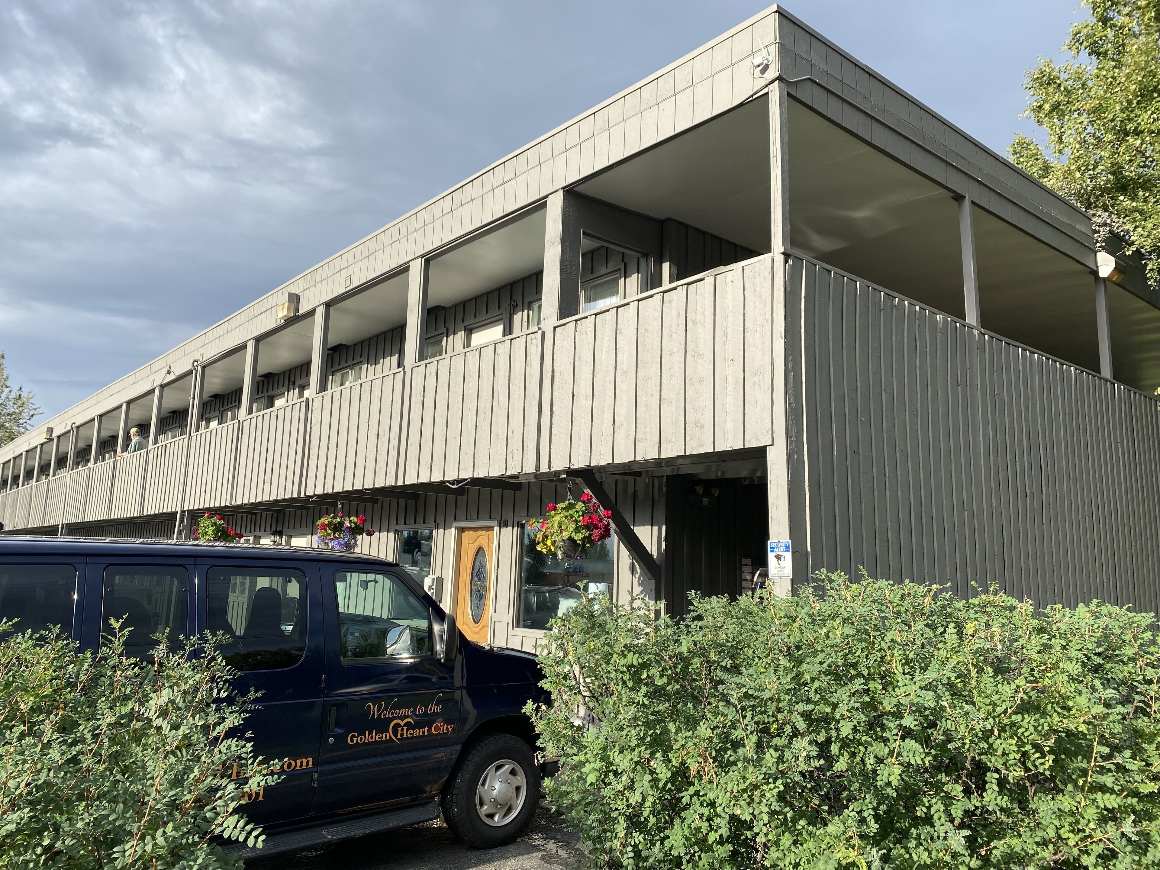 Un parking à étages doté d’un design moderne, comprenant plusieurs niveaux à ciel ouvert et une entrée abritée.