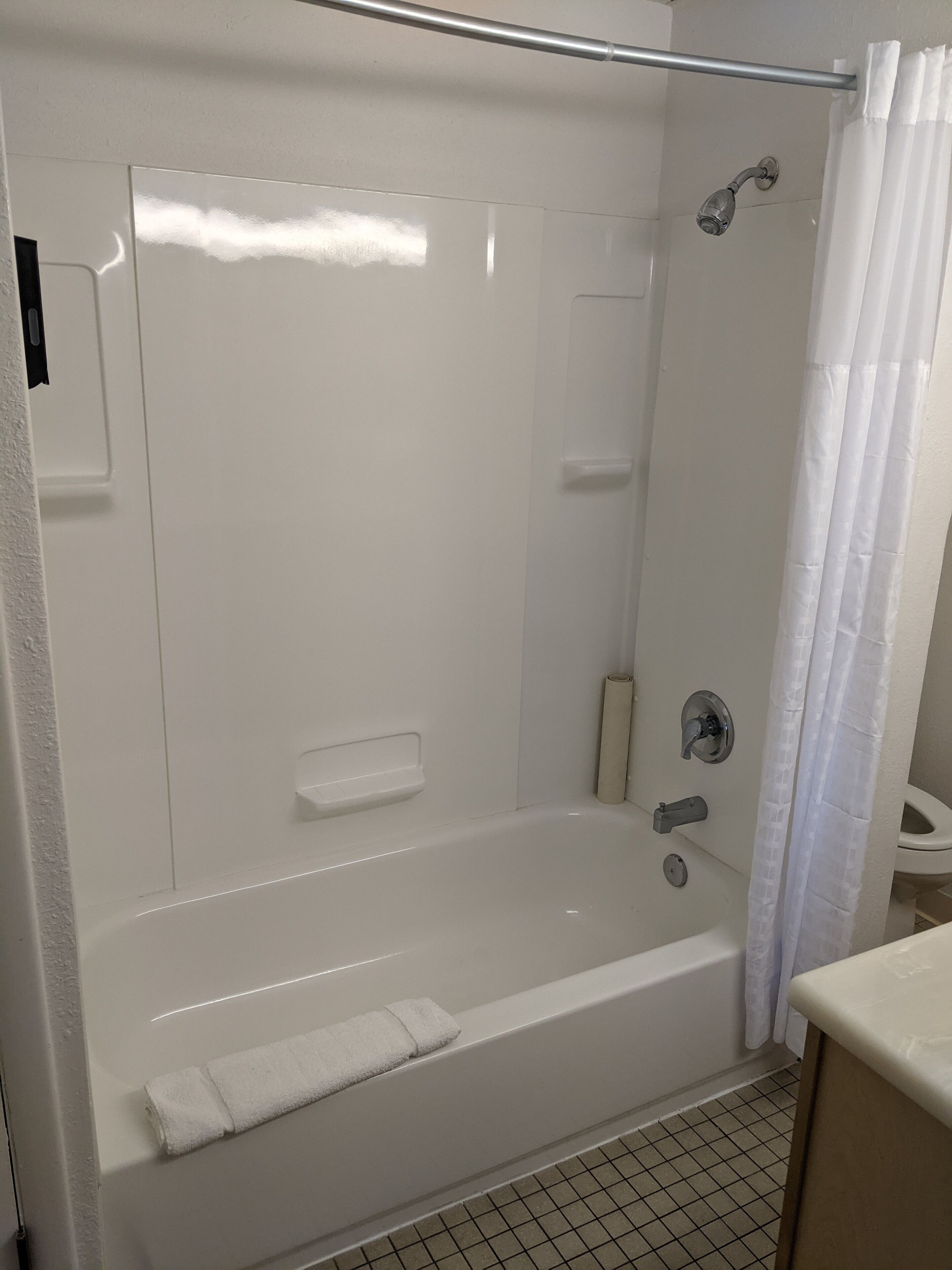 Een moderne badkamer met een inloopdouche, een badkuip en een toilet.