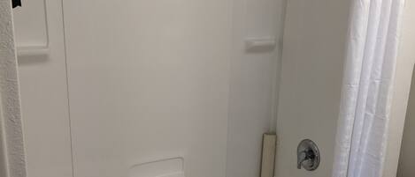 Een moderne badkamer met een inloopdouche, een badkuip en een toilet.