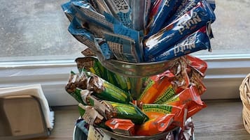 Un recipiente metálico lleno de diversos aperitivos envasados.