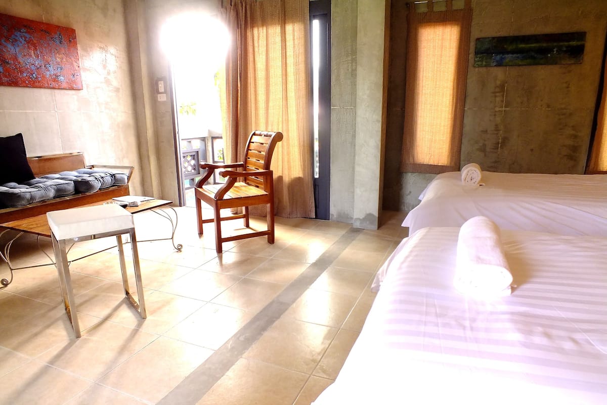Ein Hotelzimmer mit Bett, Schreibtisch, Stuhl und einem fenster mit Vorhängen.