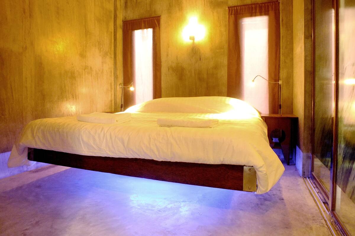 Ein Schlafzimmer mit einem großen Bett, Holzwänden und zwei Wandleuchten.