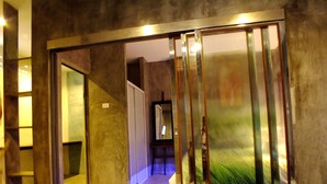 A hallway with a sliding glass door leading to a room. - The Cave Studio Samui (Koh Samui)