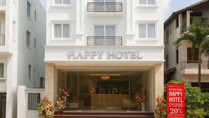 Un hotel de varios pisos con entrada central, balcones en cada planta y un cartel que indica un descuento del 20%.