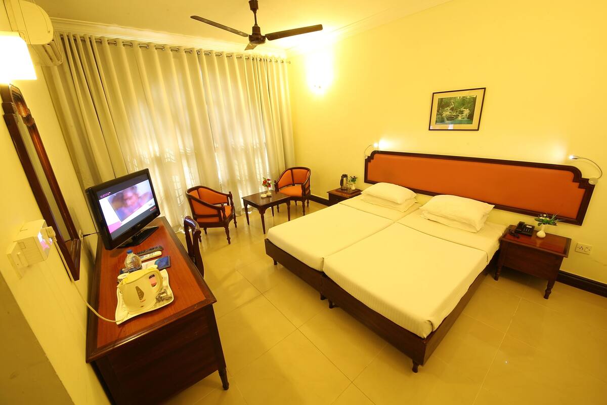 Deluxe A/C Room | Minibar, in-room safe, desk, iron/ironing board