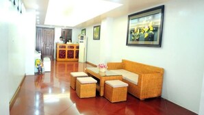 A reception area with a reception desk, a sofa, and a coffee table. - Hanoi New Hotel (Hanoi)