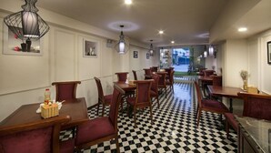 A restaurant with checkered flooring, wooden tables and chairs, and pendant lighting. - Hanoi New Hotel (Hanoi)