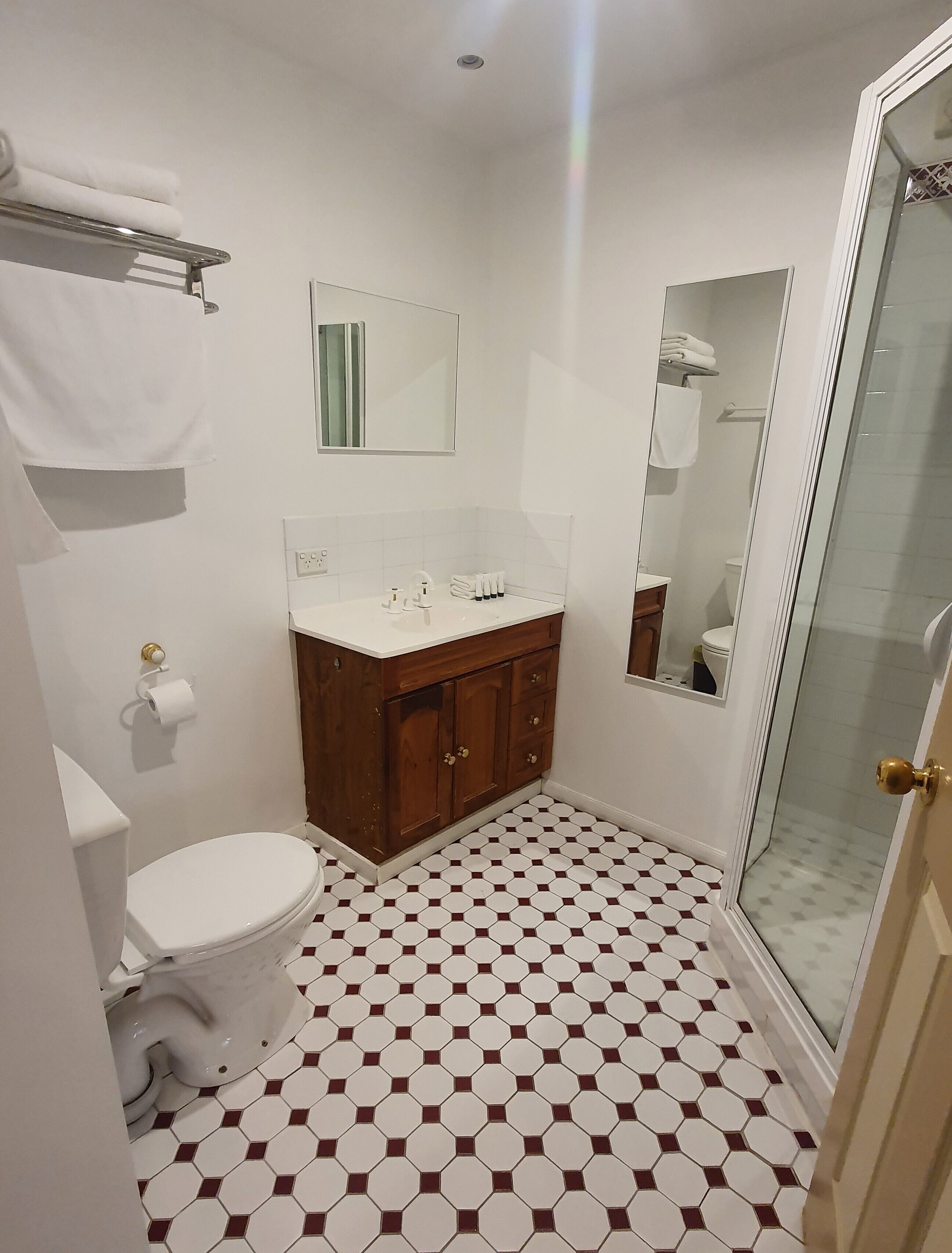 Et badeværelse med toilet, håndvask og bruser.