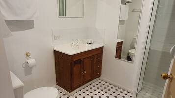 Et badeværelse med toilet, håndvask og bruser.