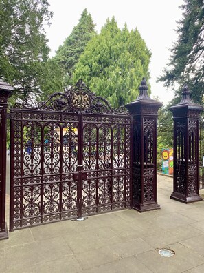 Stunning entrance to a beautifully maintained outdoor space, flanked by ornate lanterns.