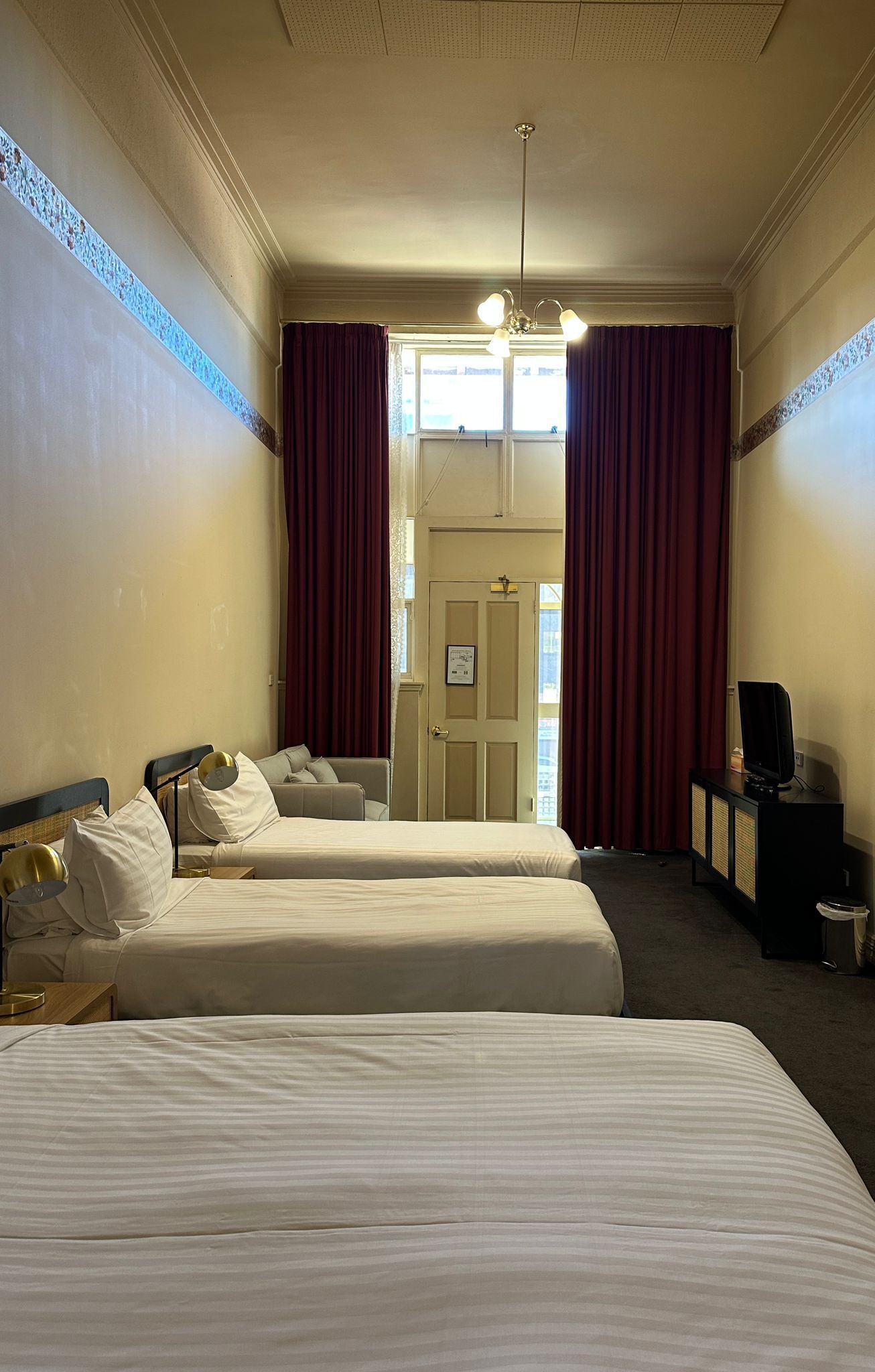 Ein Hotelzimmer mit zwei Betten, einem Fernseher und einem Schreibtisch.