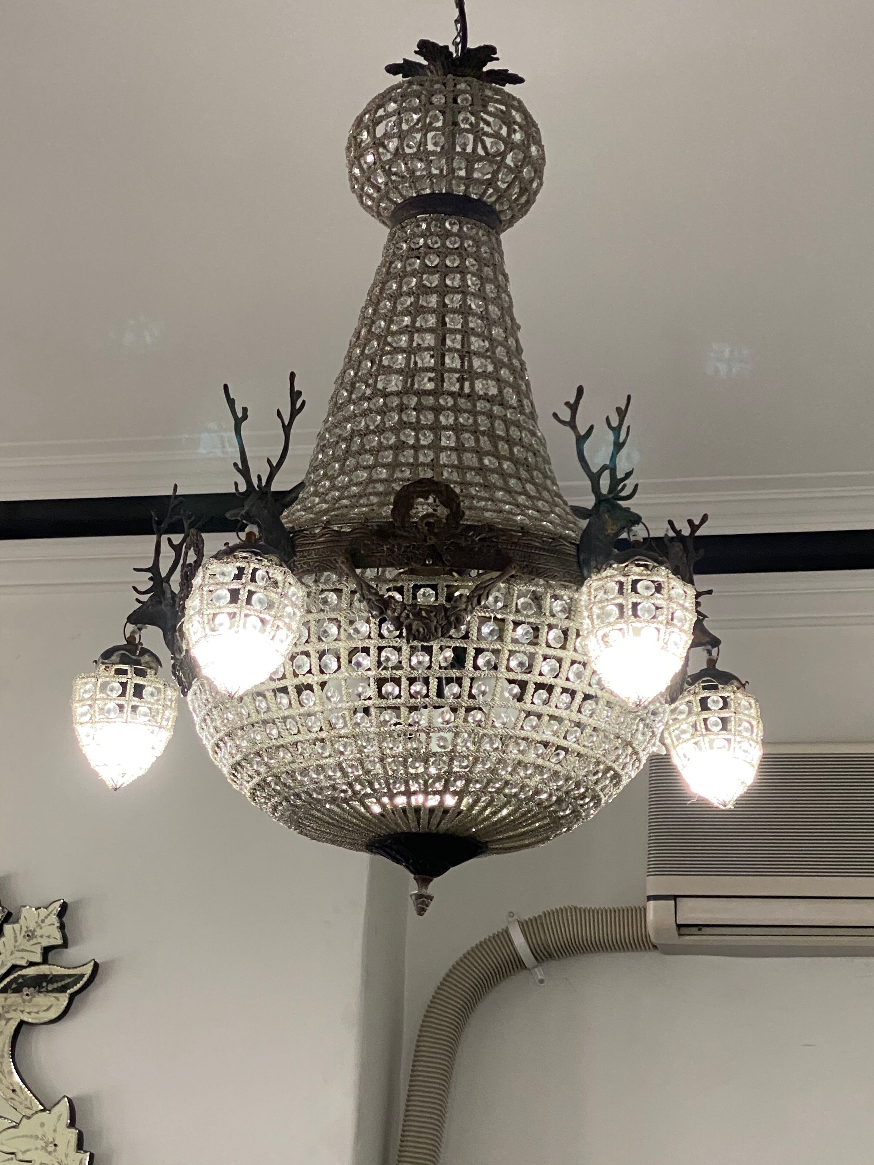 A chandelier with multiple crystal lights and antler decorations.