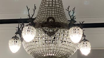 A chandelier with multiple crystal lights and antler decorations.