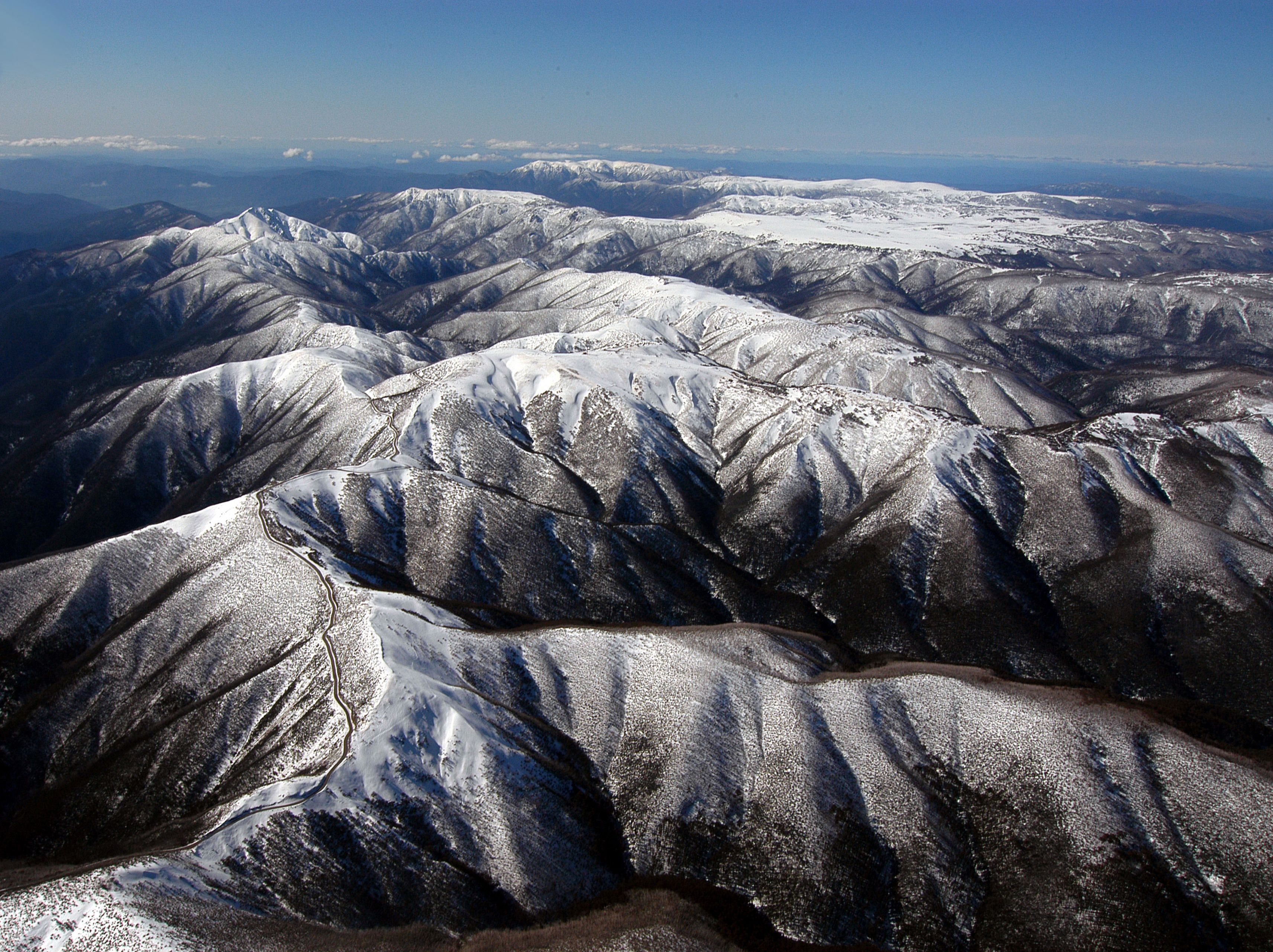 Un paisaje montañoso con picos y valles nevados.