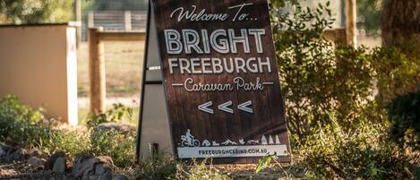 A wooden sign welcoming visitors to Bright Freeburgh Caravan Park.
