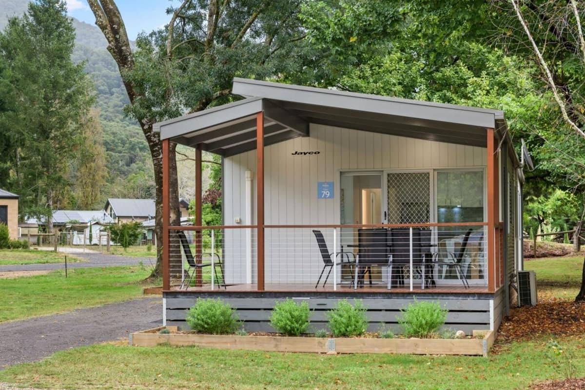 A small, single-story building with a covered porch, a sign reading "Jayco," and a number "79" on the door.