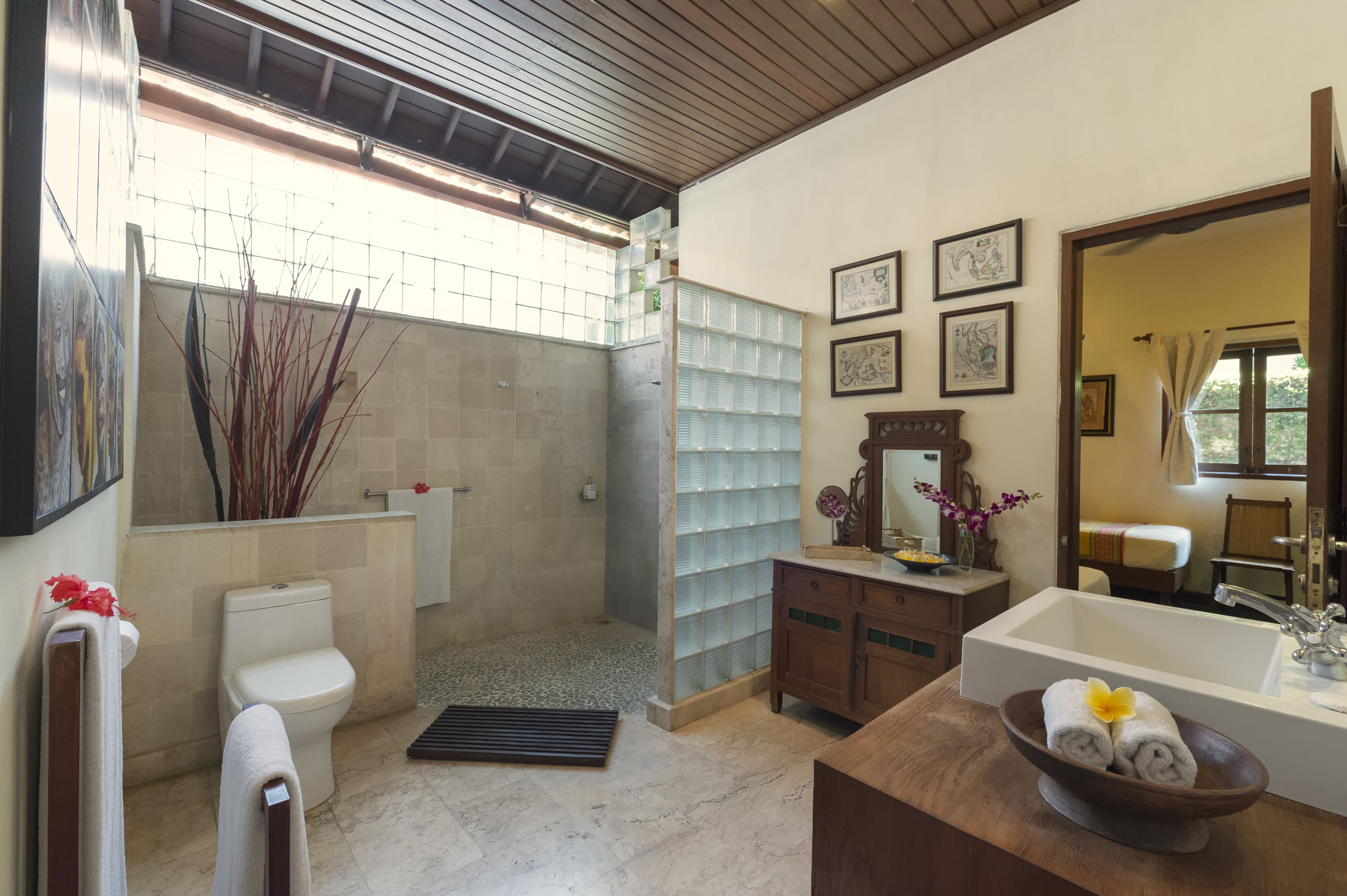 Un baño con inodoro, ducha, lavamanos y espejo.