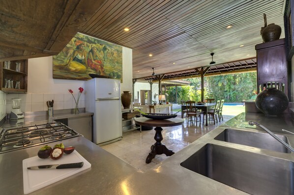 Una cocina moderna con una isla central, un comedor con vistas y un cuadro grande en la pared.
