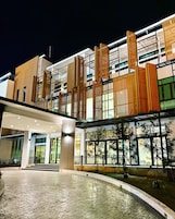 A modern hotel with a spacious lobby, large windows, and a well-lit entrance.