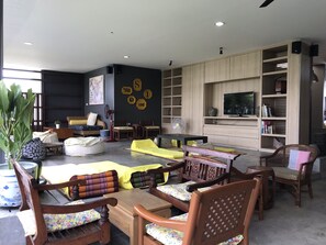 A modern living room with a sofa, chairs, a coffee table, and a TV mounted on the wall.