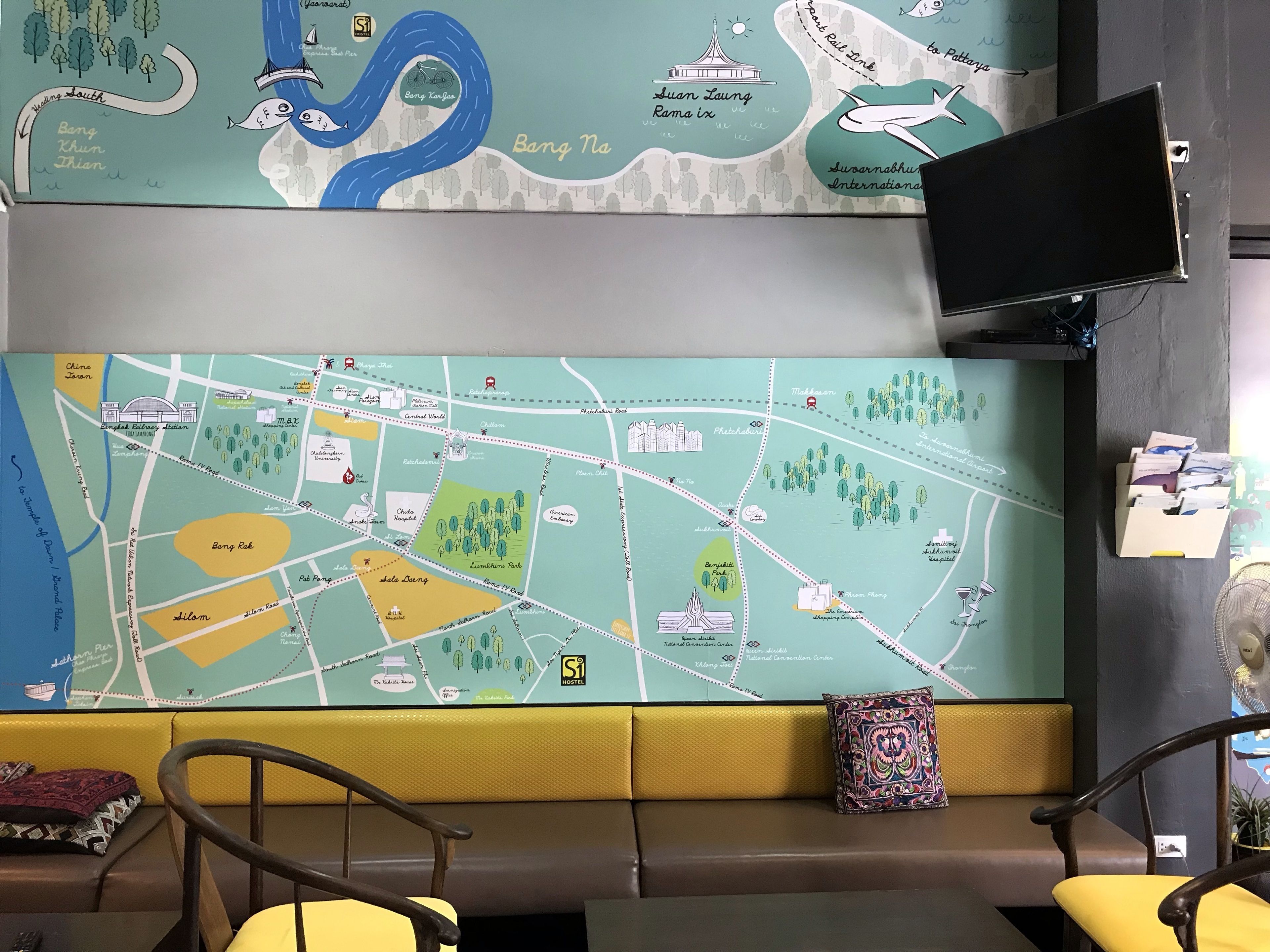 A map of a city with landmarks and a seating area with a television and a fan.