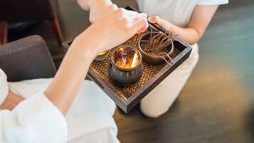 A tray with a candle and a small bowl of dried plants.