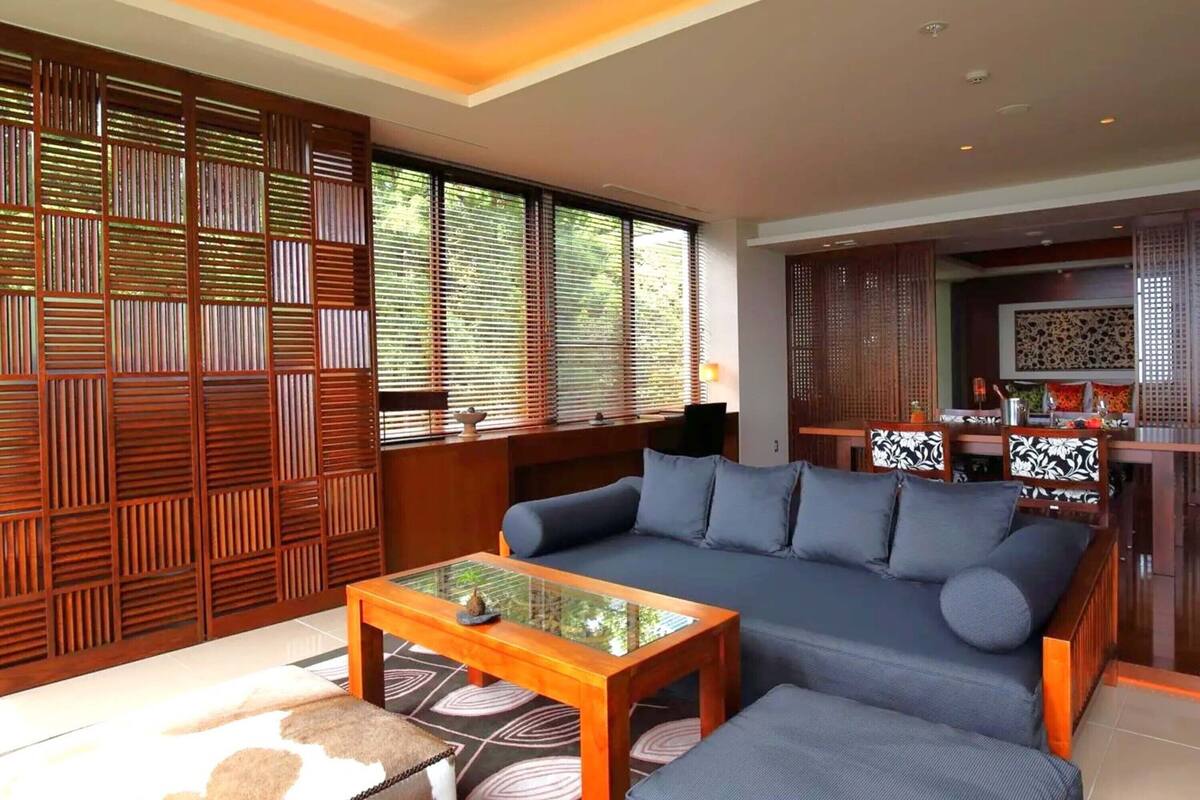 A modern living room with a sofa, ottoman, and coffee table.