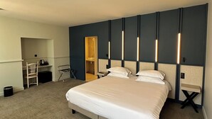 A modern hotel room with a large bed, a desk, and a chair. - Hôtel Médieval (Avignon)