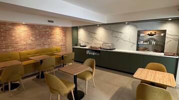 A modern lounge area with a brick accent wall, a marble backsplash, and a seating arrangement including sofas and tables.