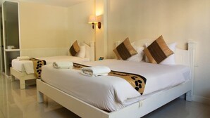 Habitación de hotel con dos camas, un espejo grande y una lámpara de pared.