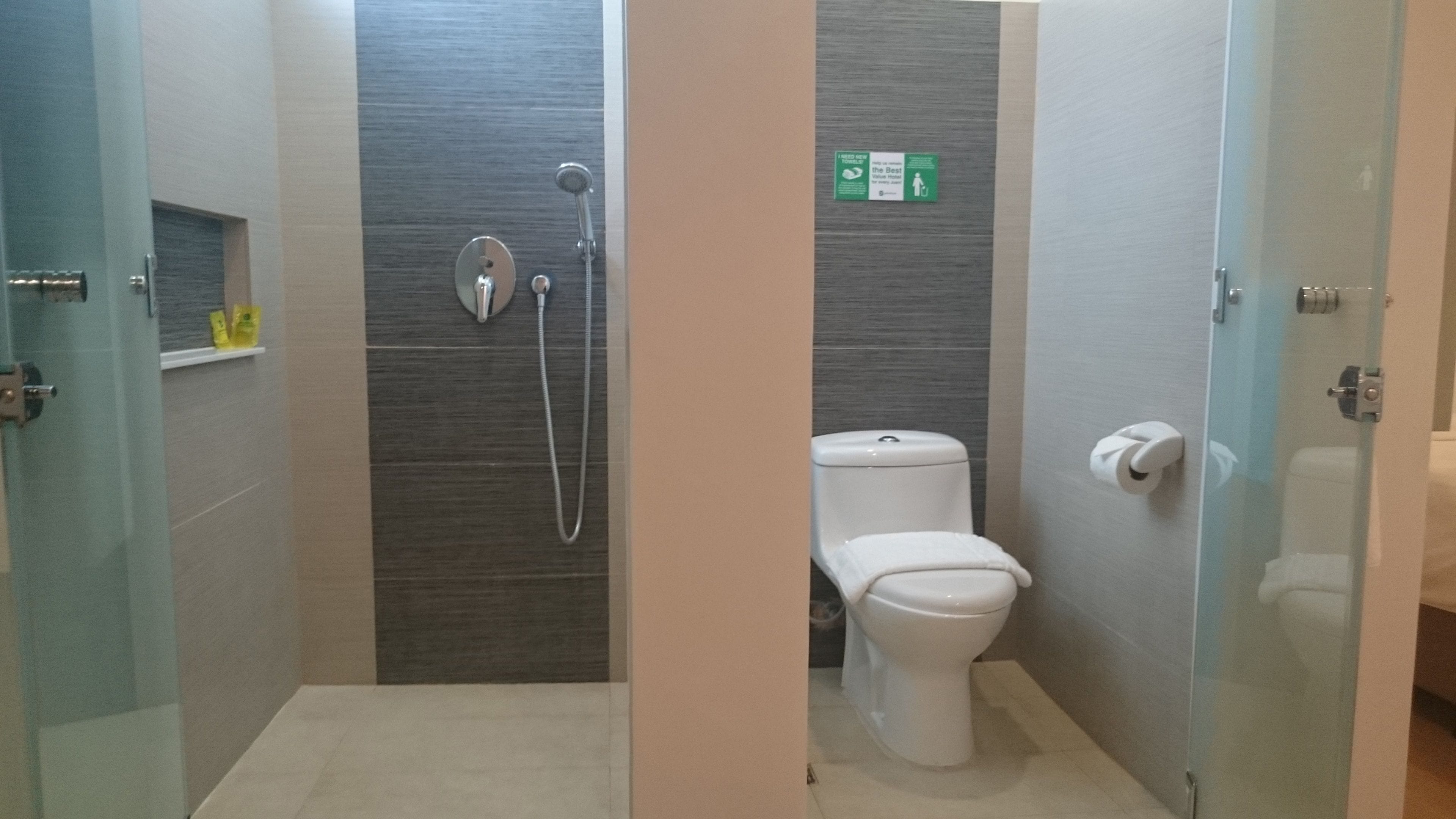 Un baño moderno con ducha, inodoro y puertas de vidrio.