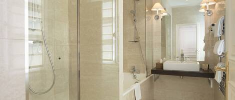Une salle de bain moderne avec une douche à parois de verre, un lavabo avec un meuble-vasque et un miroir avec éclairage intégré.
